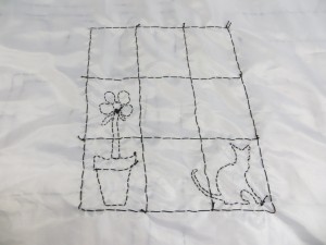 detail of the window with plant and cat - stitched fabric
